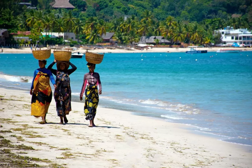 Plaża na Madagaskarze i kobiety niosą kosze